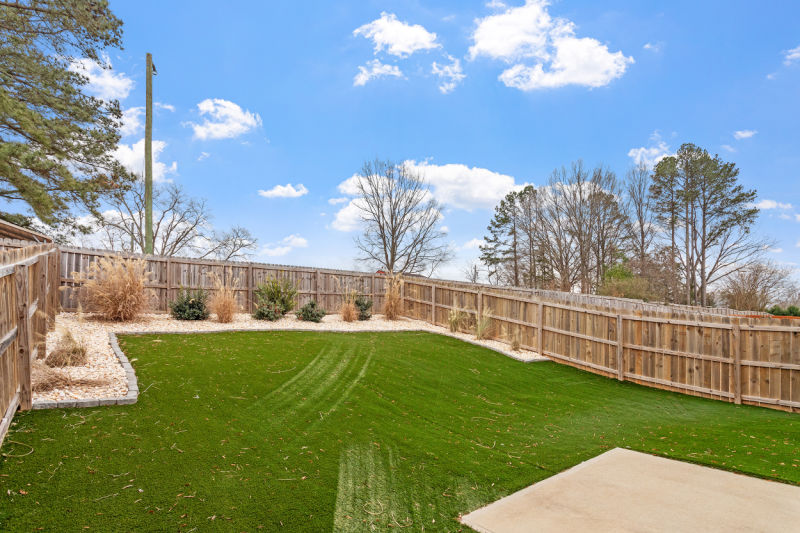 36 Schoolhouse Way, Clayton NC, fenced backyard with artificial turf lawn, beautifully landscaped.